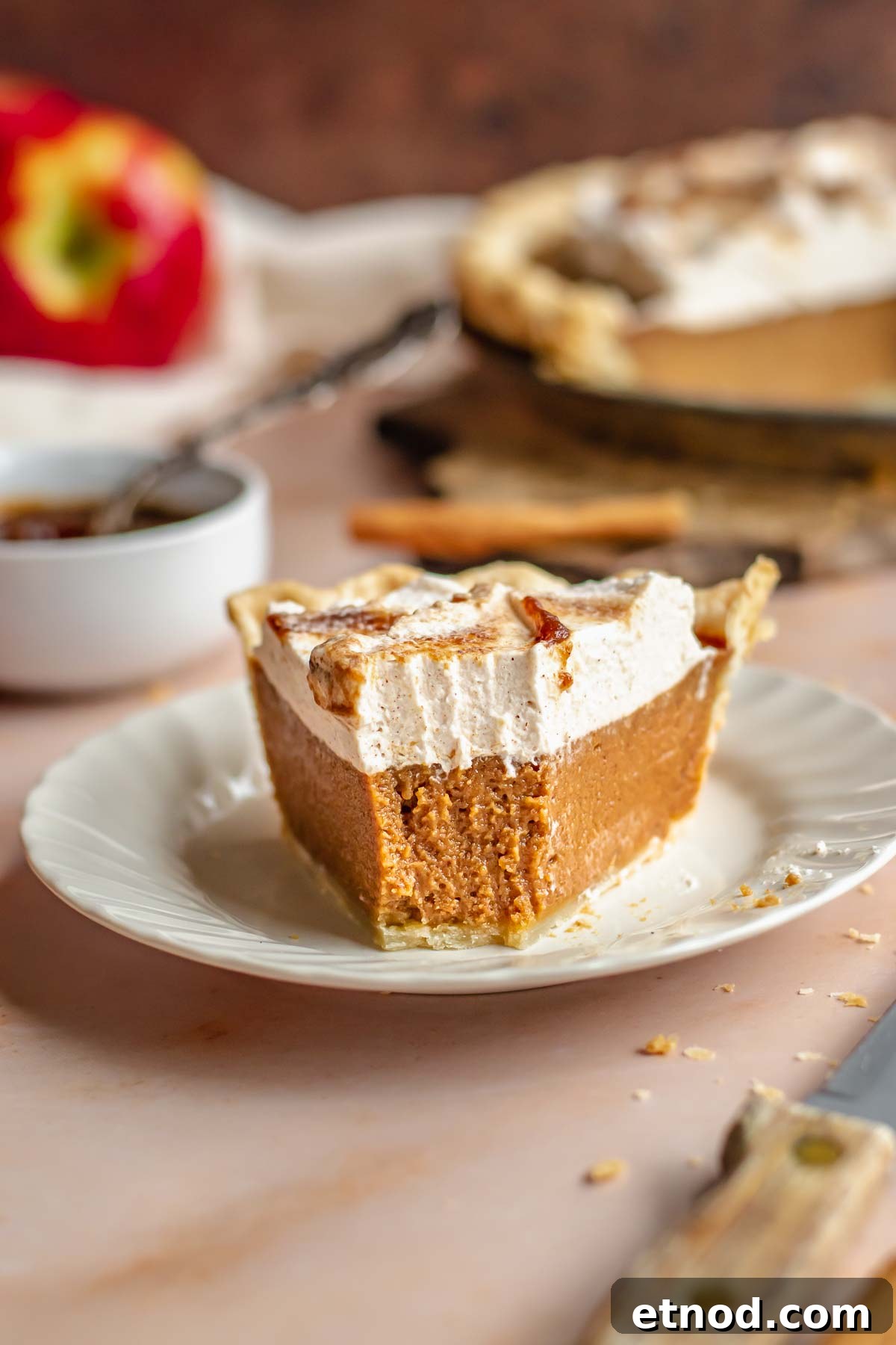 A slice of apple butter pie on a plate with a bite removed.