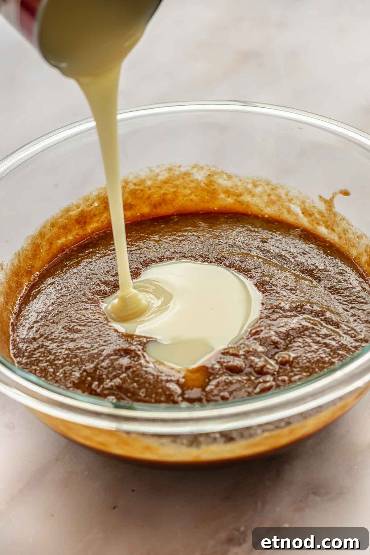 Sweetened condensed milk pouring into the filling.