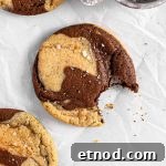 Chocolate marble cookies with flaky salt on parchment paper.