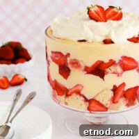 Gluten-Free Trifle Recipe: Light, Layered Dessert for Guests 10 Gluten free trifle in a footed glass bowl on a pink background.