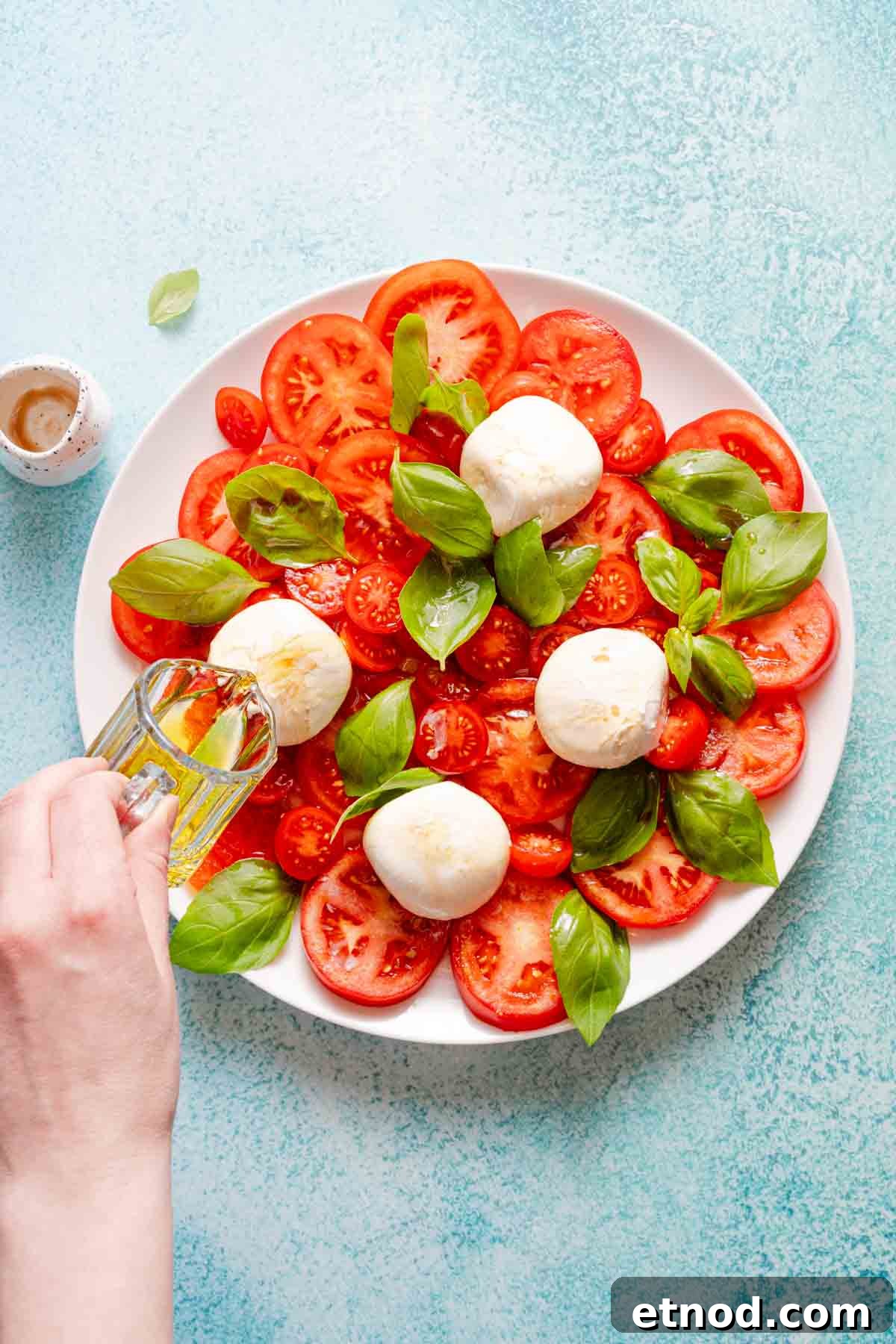 Creamy Burrata Caprese Salad with Heirloom Tomatoes 8 olive oil being drizzled over caprese salad.