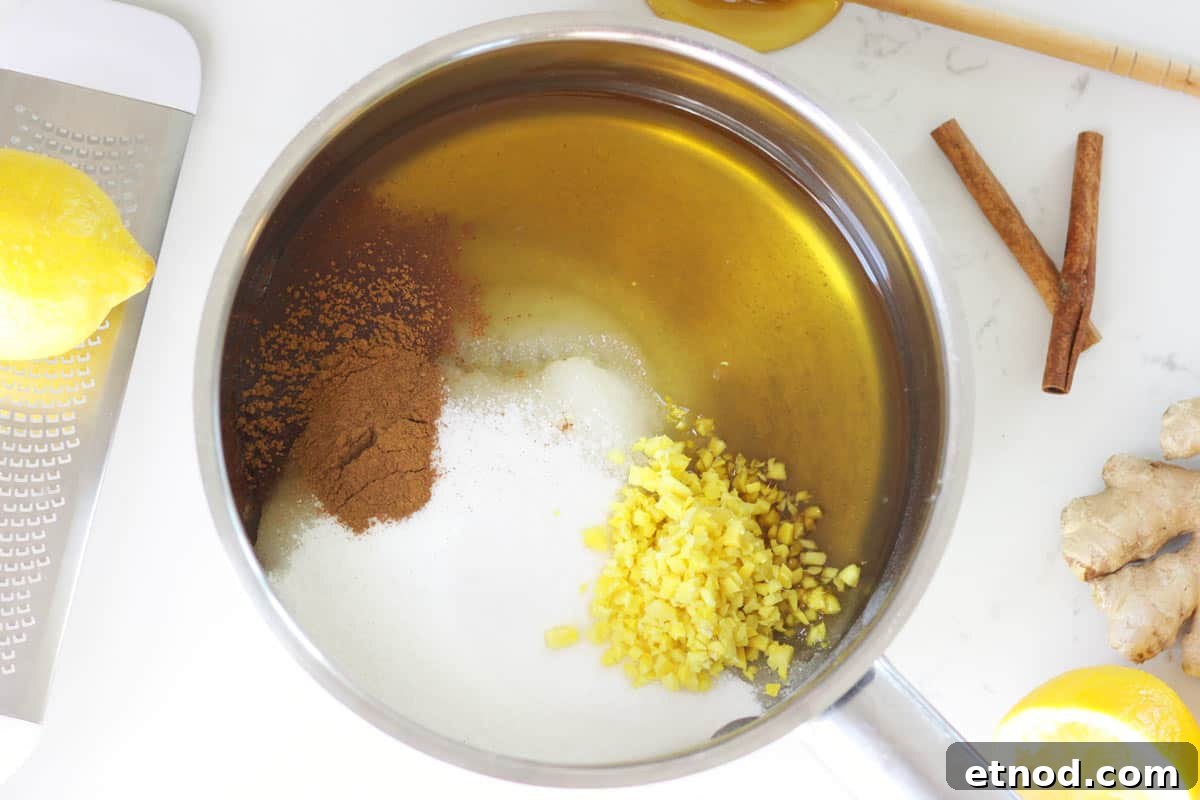 DIY Lemon, Honey & Ginger Cough Drops Recipe for Soothing Relief 4 a saucepan with honey, sugar, chopped fresh ginger and cinnamon in it.