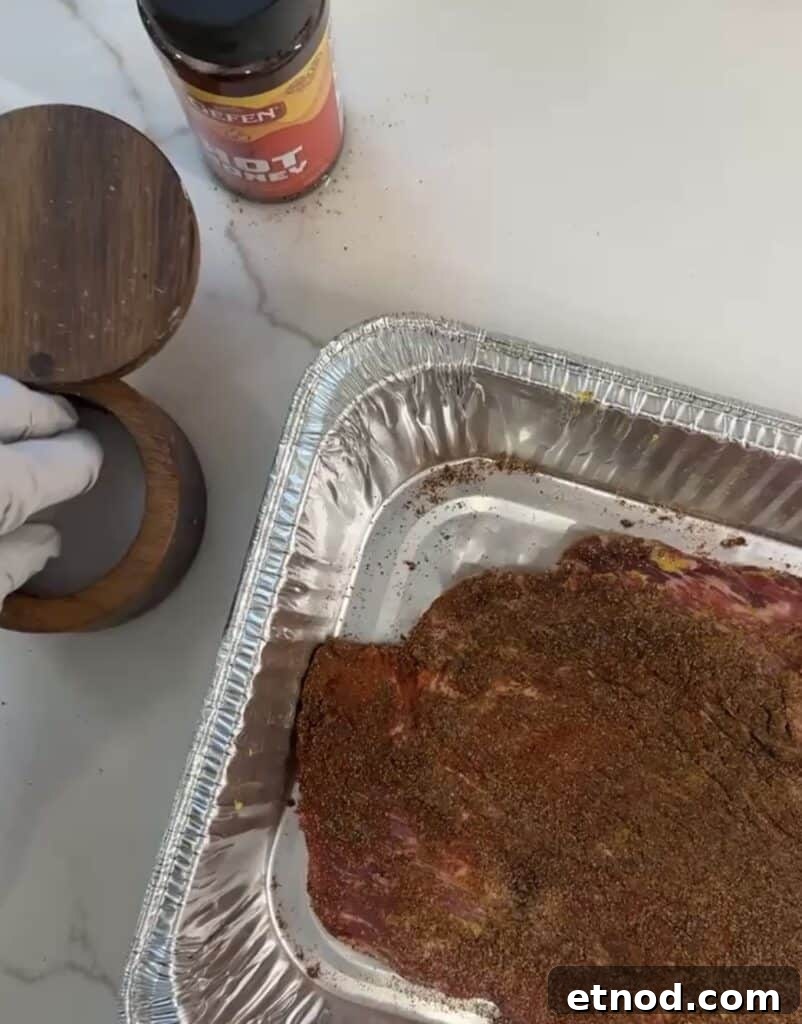 Oven-Baked Burnt Ends with Hot Honey Barbecue Glaze 3 putting rub on meat in the pan