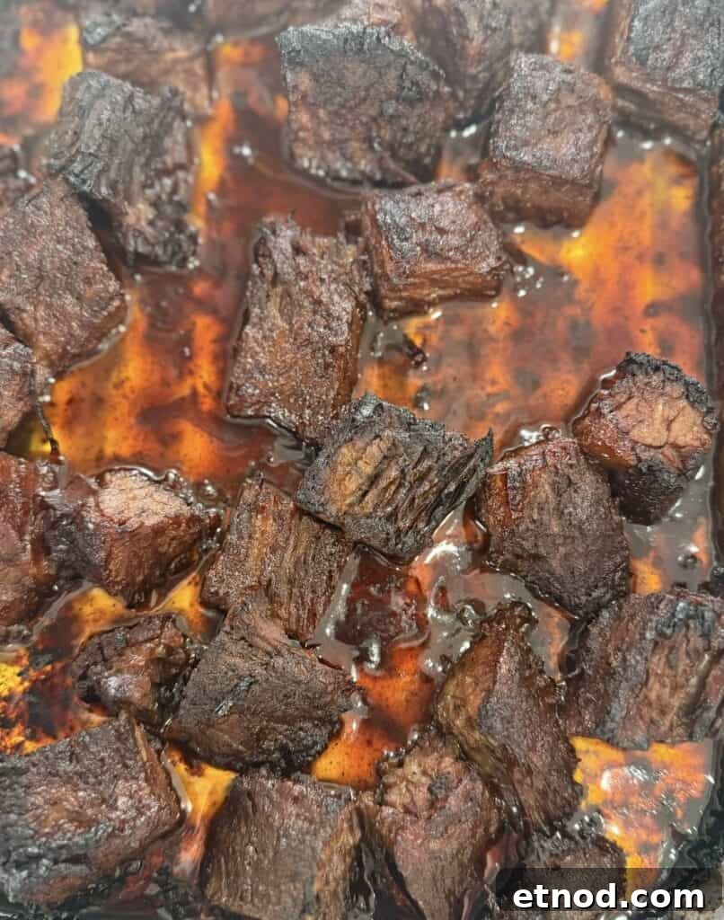 Oven-Baked Burnt Ends with Hot Honey Barbecue Glaze 4 pouring sauce over oven baked burnt ends