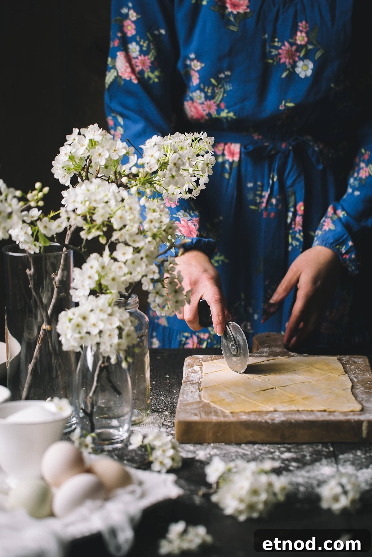 Woman cutting out bugnes dough in the shape of diamonds with a pizza cutter