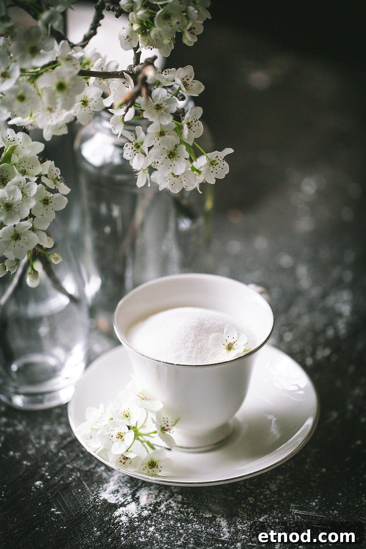 sugar in teacup surrounded by white cherry blossoms for no yeast beignets to eat in spring