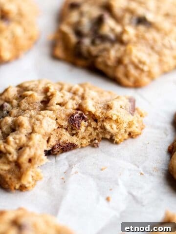 Oatmeal cookie with a bite taken out on a baking sheet