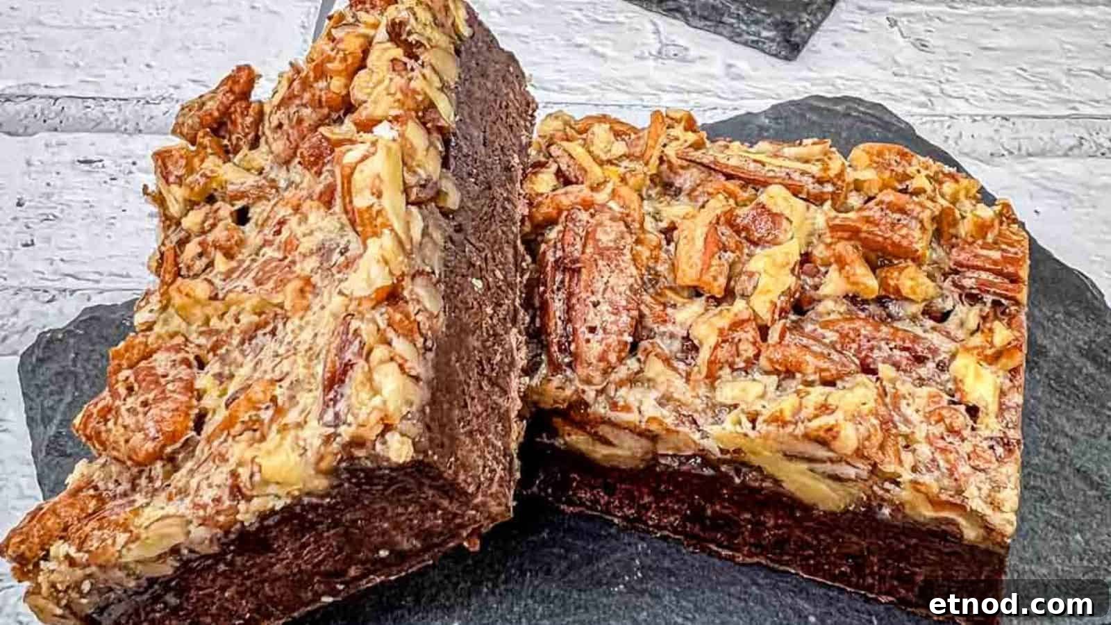 21 Quirky-Looking Desserts That Disappear First at Parties 21 A close-up of two pecan brownies on a slate surface, showing the rich, chocolatey interior and a topping of chopped pecans.