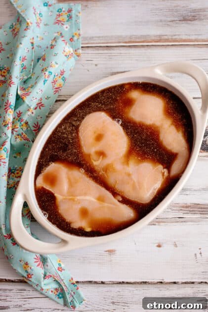 Marinated chicken breasts in baking dish.