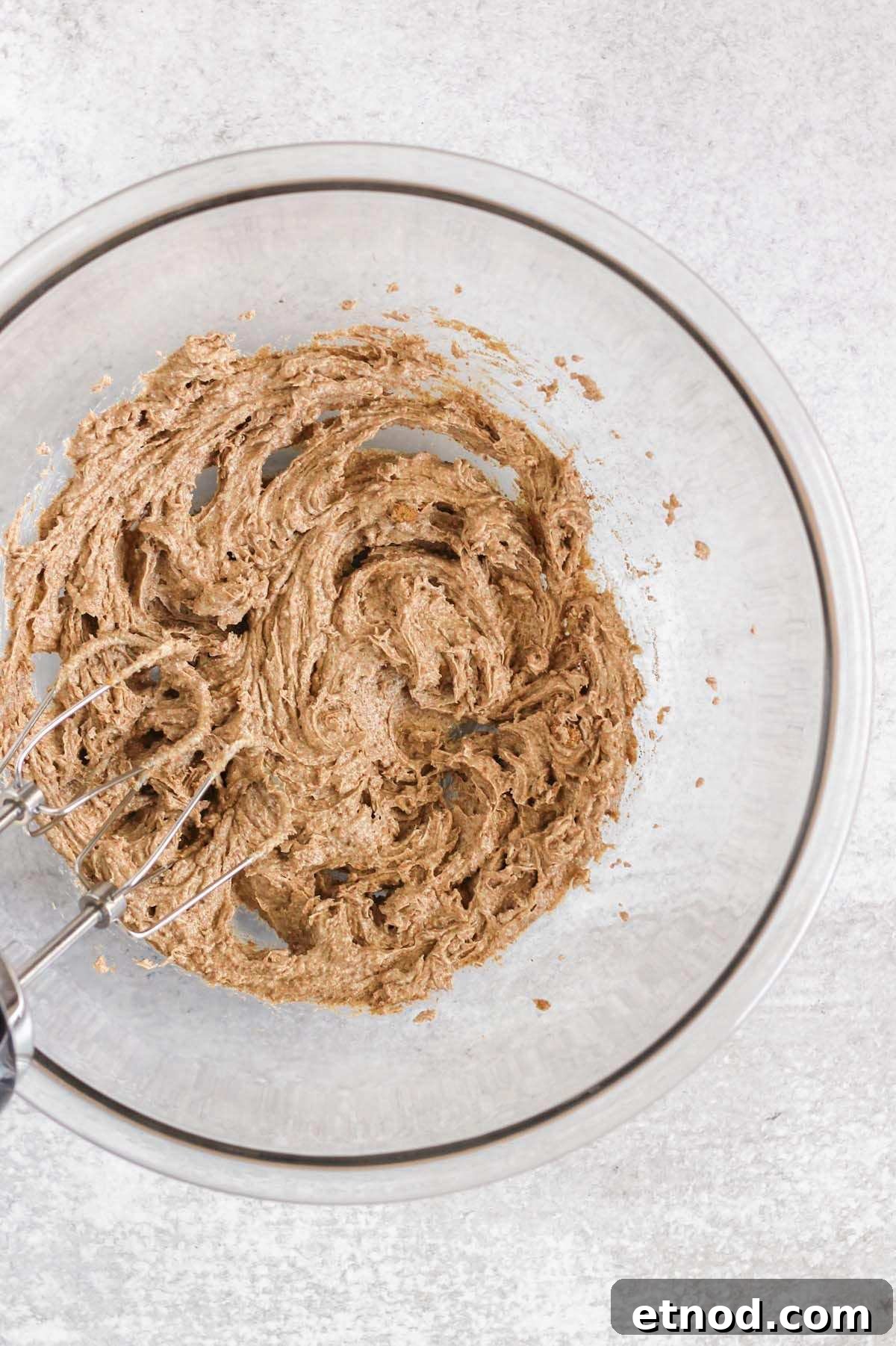 Butter and coconut sugar creamed together in a glass mixing bowl.