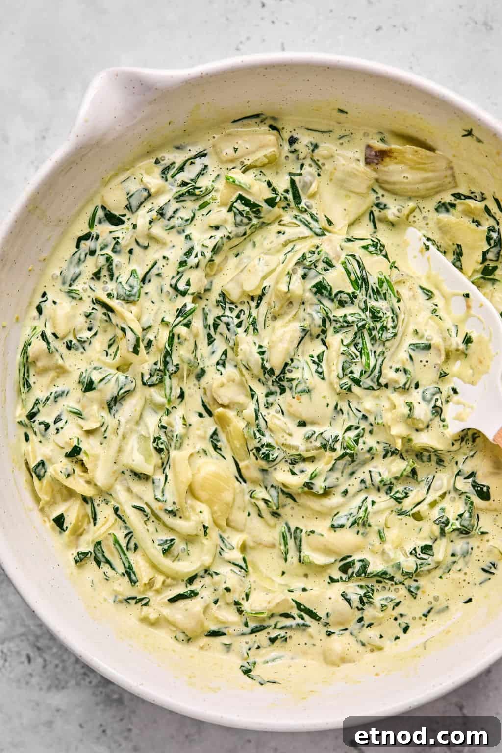 creamy spinach mixture combined in a mixing bowl.