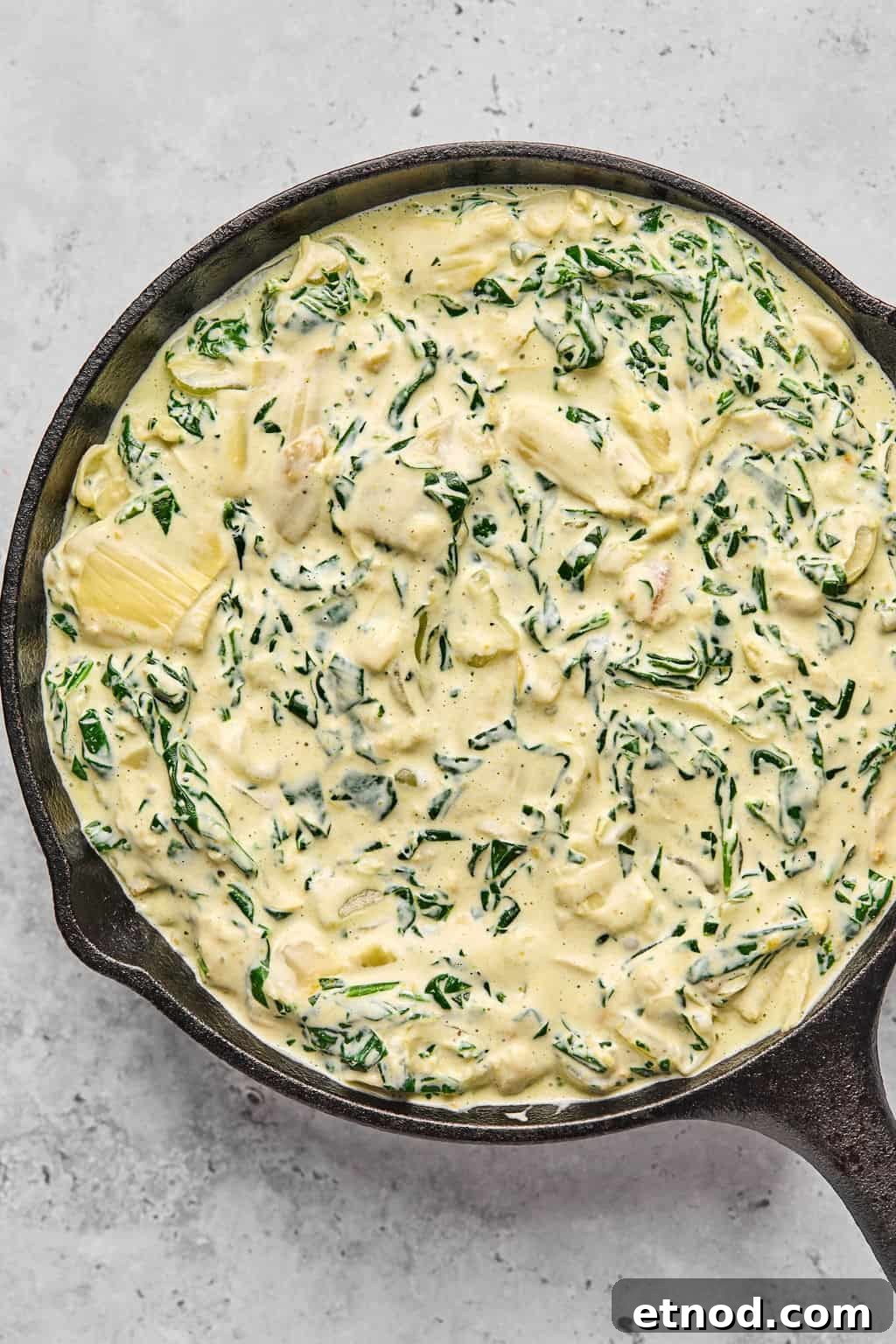 unbaked dip in a cast iron skillet.
