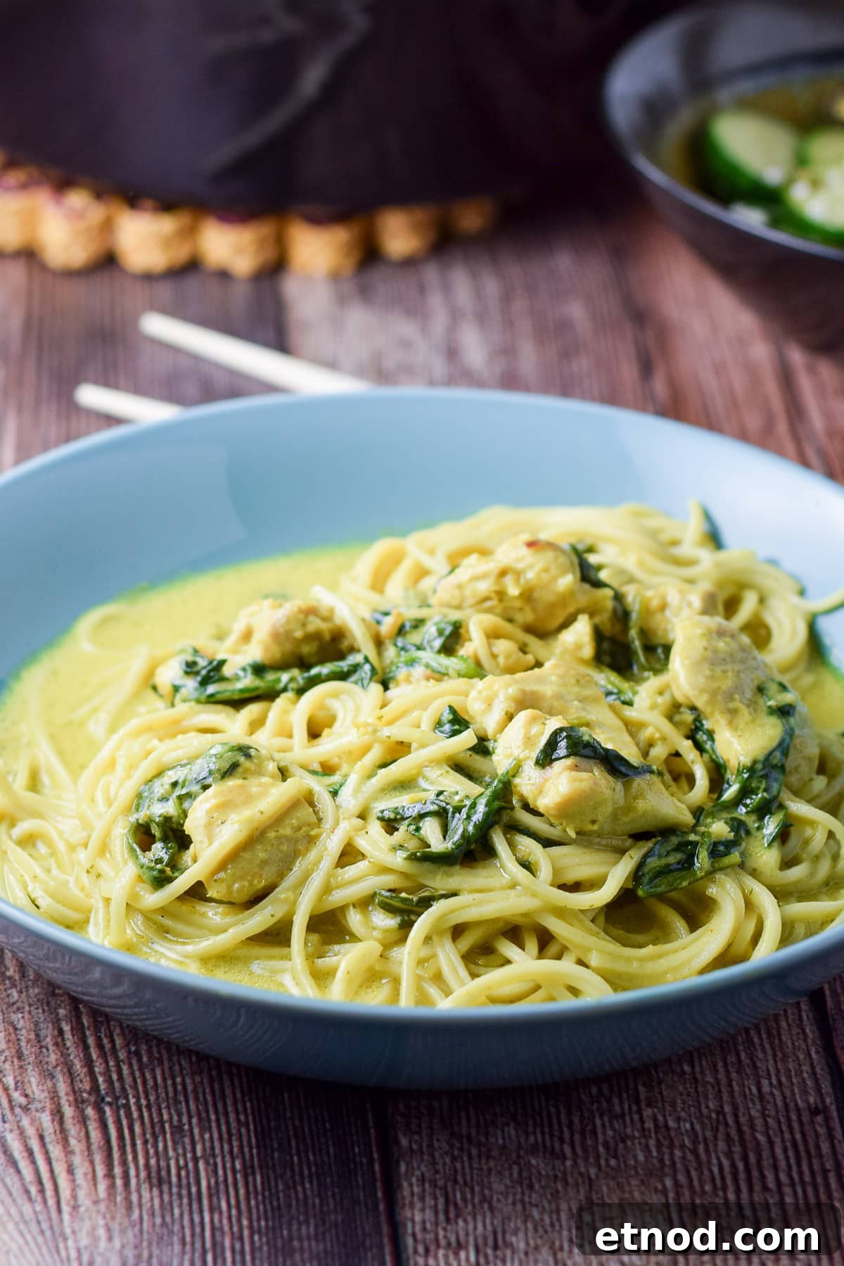 Spicy Chicken Curry Noodles with Coconut and Lime 2 A blue deep dish with noodles, spinach, chicken, and curry sauce