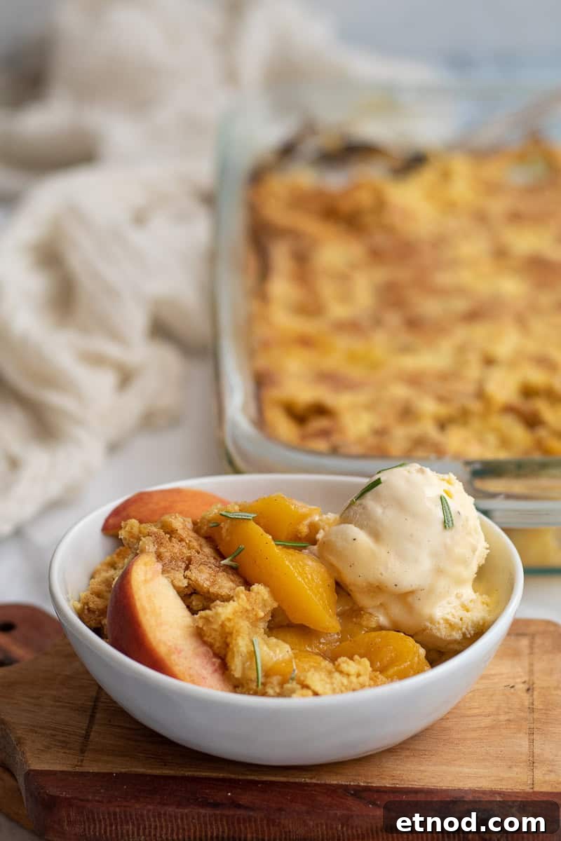 5-Ingredient Peach Cobbler Using Cake Mix Recipe 2 peach cobbler in a white bowl with baking dish behind it