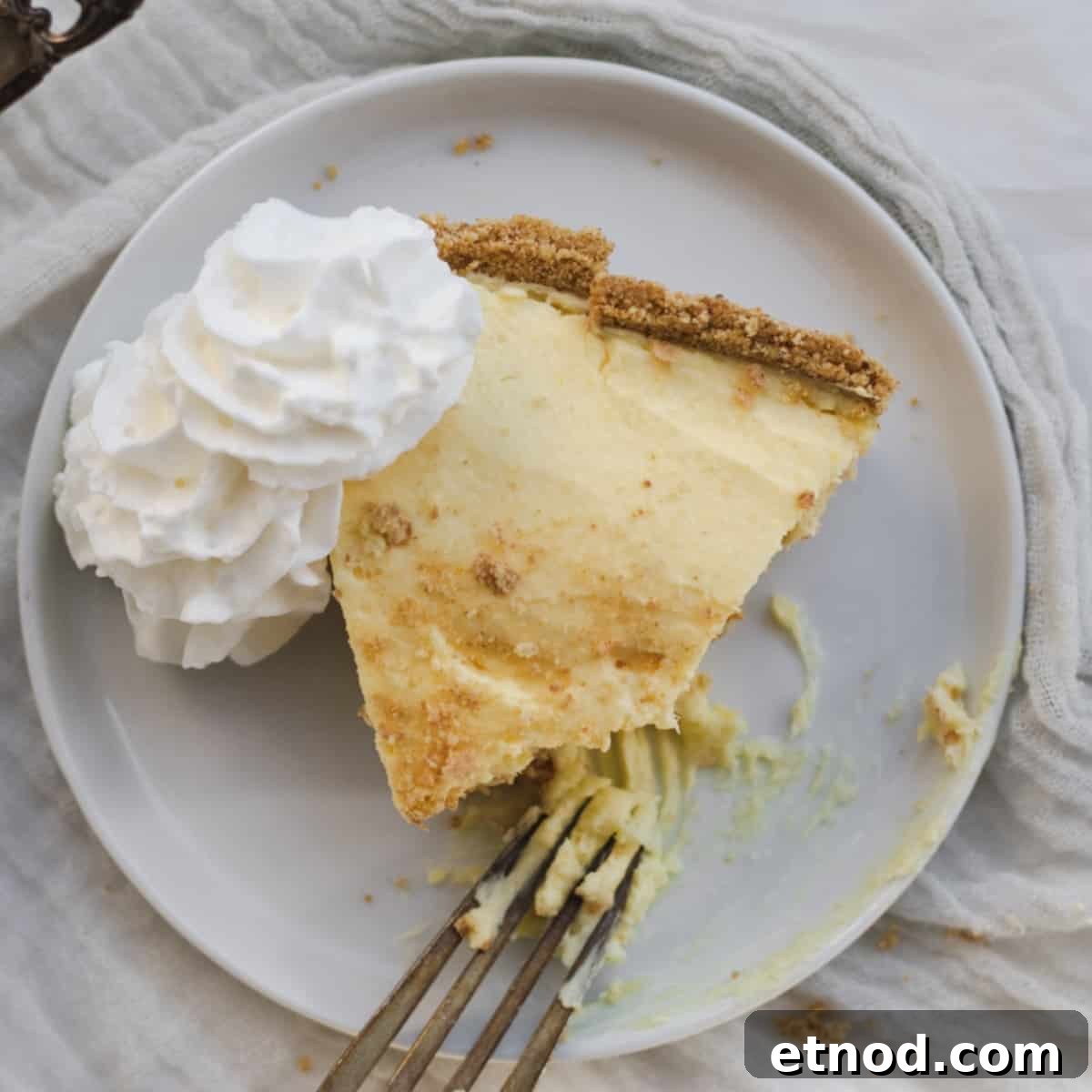 slice of pudding pie on a plate with whip cream and a fork