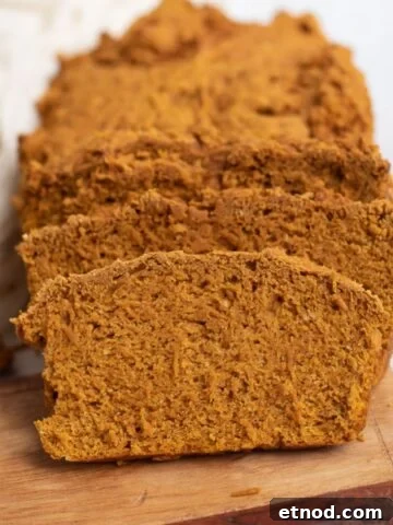 Sliced pumpkin bread on a wooden serving board