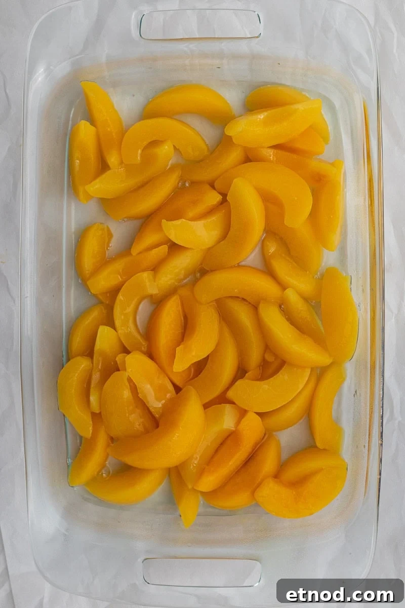 5-Ingredient Peach Cobbler Using Cake Mix Recipe 4 canned peaches in a glass baking dish