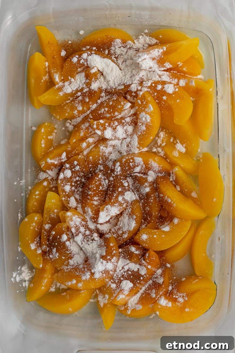 5-Ingredient Peach Cobbler Using Cake Mix Recipe 5 cornstarch and cinnamon with peaches in a glass baking dish