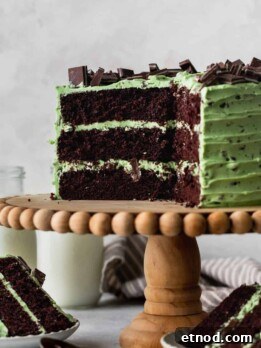 Andes Mint Chocolate Cake Recipe: Rich, Decadent Layer Cake 14 Chocolate mint cake on a cake stand with cake slices around it.