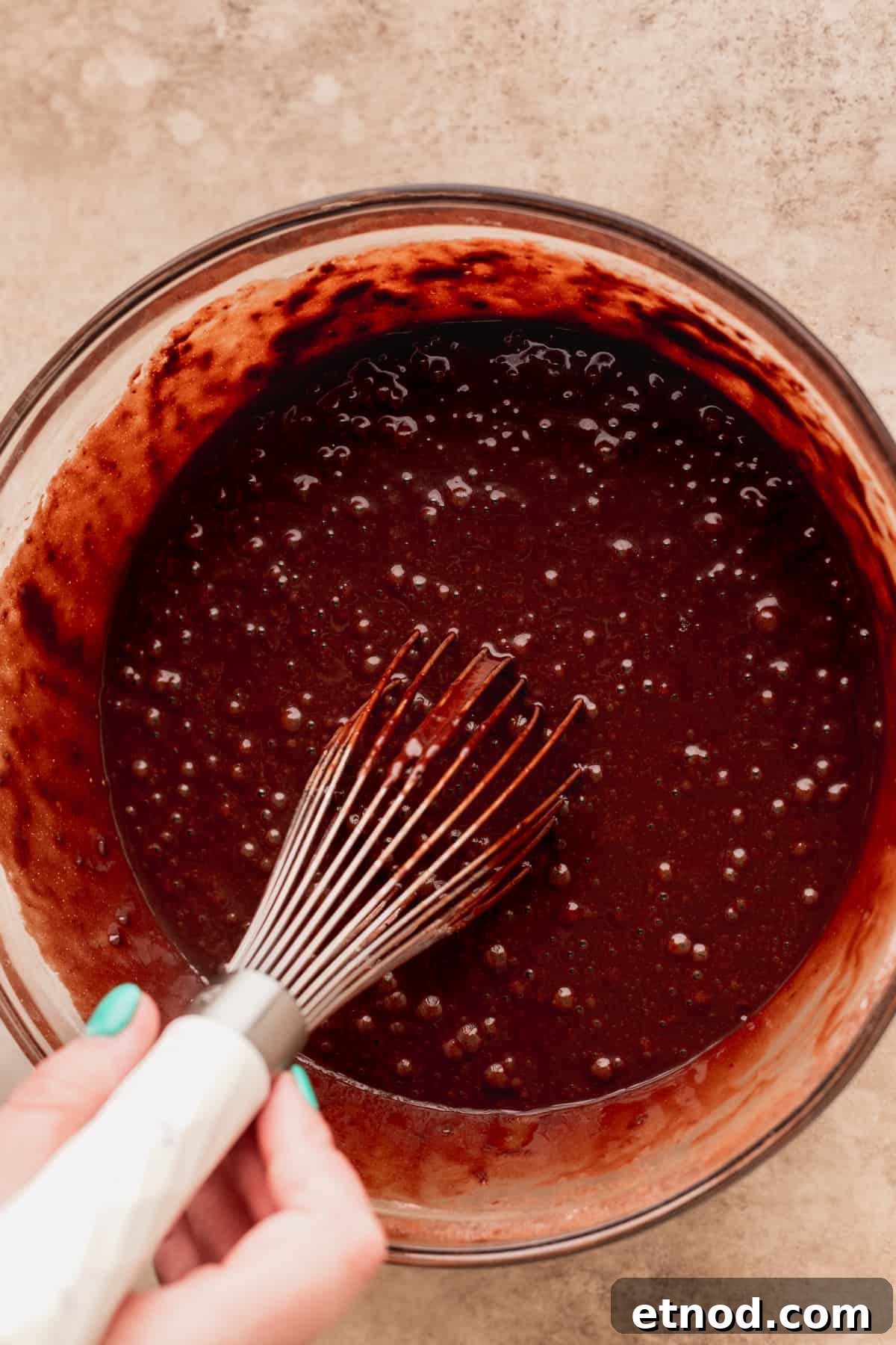 Andes Mint Chocolate Cake Recipe: Rich, Decadent Layer Cake 5 Stirring chocolate cake batter in a glass bowl.